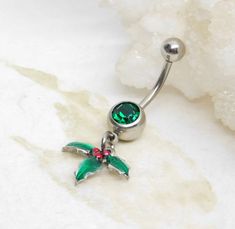 "Christmas Holly Belly Ring 14g surgical stainless steel belly bar features a festive holiday charm with bright enamel colors. Belly button ring measures 1 1/2 inches long total length. Barbell is 14g surgical steel. Top ball measures 5mm, bottom ball measure 8mm. Charms are made from a \"pewter\" (zinc-based alloy) base. For Belly Button Rings: https://www.etsy.com/shop/AllAboutClass?section_id=18474235&ref=shopsection_leftnav_1 All body jewelry sales are final!! AllAboutClass DOES NOT accept a Emerald Belly Button Piercing, Belly Button Piercing Red, Adjustable Green Belly Rings As Gift, Christmas Belly Button Rings, Belly Button Rings Emerald, Belly Button Rings Tummytoys® At The Belly Ring Shop, Belly Bar, Bellybutton Piercings, Belly Piercing Jewelry