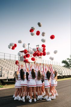 a group of cheerleaders standing in front of an empty bleachers with pom - poms