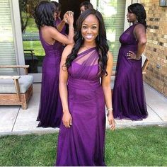 a woman in a purple dress posing for the camera with three other women behind her