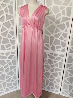 This is a sweet v neck sleeveless satin nylon nightgown with a plaited tie under the bust and ties at the back. It is new old stock with tags by Jillray made in Australia in the 60s or 70s. It is a long below knee length  Condition is very good  Bust 96cm Length shoulder to hem 142cm Summer Satin V-neck Nightgown, Spring Evening V-neck Sleepwear, Satin V-neck Summer Nightgown, Spring Evening V-neck Nightgown, V-neck Spring Sleepwear, V-neck Evening Sleepwear For Spring, Sleeveless Satin Dress For Sleepover, Pink Satin V-neck Nightgown, Feminine V-neck Party Nightgown