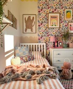 a bedroom with a bed, dresser and pictures on the wall