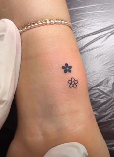 a small four leaf clover tattoo on the right side of the ankle, with three petals in black ink