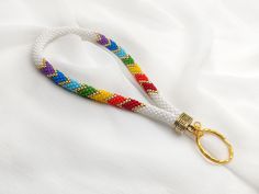 a white lanyard with multicolored beads and gold clasps on a white background