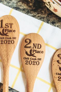 three wooden spoons with the names and date printed on them