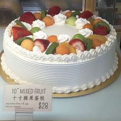 a white cake with fresh fruit on top is for sale at a store in china