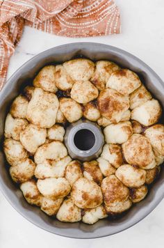 a bundt cake in a pan on a white table with a cloth and napkin