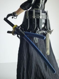 an action figure holding two swords and wearing a black outfit with chains on it's belt