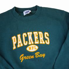 This vintage Green Bay Packers crewneck sweatshirt, made by Nutmeg Mills in the 1990s, is a must-have for NFL fans and retro lovers. Featuring bold "PACKERS NFL" lettering with the iconic football graphic, this classic sweatshirt celebrates the Green Bay Packers in style. The forest green base with bright yellow and white accents offers a timeless, sporty look. In men's size medium, it's perfect for casual wear or showing your team pride on game day. Durable and comfortable, this piece embodies Green Bay Packers Sweatshirt, Packers Sweatshirt, Nfl Vintage, Sports Sweatshirt, Nfl Packers, Nfl Green Bay, Classic Sweatshirt, Vintage Sportswear, Nfl Fans