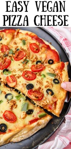 an easy vegan pizza with olives, tomatoes and cheese on a black plate