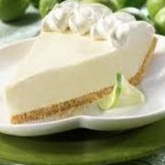 a slice of cheesecake on a plate with limes in the background