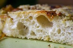 a piece of bread that has been cut in half on a green plate with other food items around it