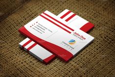 two red and white business cards on top of a burlocked cloth background