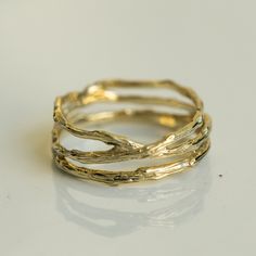 three gold rings sitting on top of a white surface with one ring in the middle