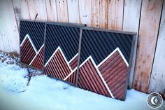 the side of a building with wooden slats in front of it and snow on the ground