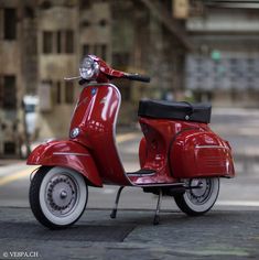 a red scooter is parked on the side of the road