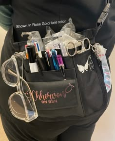 a person holding a black bag filled with lots of pens and pencils in it