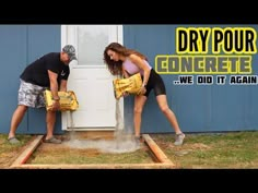 a man and woman are pouring concrete into the ground