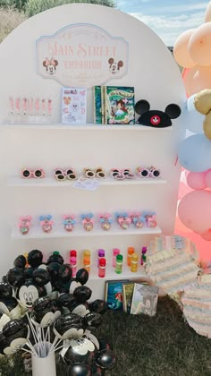 a display with balloons, mickey mouse ears and other items