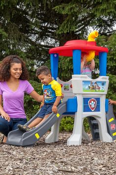 a woman and two children playing in a play set