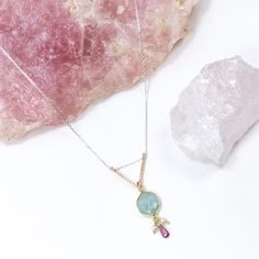 Pearls and aquamarine are the stones of the sea. This beautiful pendant is created with aquatic themes in mind using these stunning gemstones paired with a pop of color from beautiful, pnk, rhodolite garnet. This gorgeous blend of stones is accented with a hand forged, sparkling gold v shaped pendant and delicate sterling silver chains. •14k gold filled and sterling silver •Aquamarine, freshwater pearl, and rhodolite garnet •Pendant Dimensions: 1/2 x 1.75" •Length: 17" Elegant 14k Gold-filled Necklaces With Natural Stones, Handmade Ocean Jasper Nature-inspired Necklace, Handmade Ocean Jasper Pendant Jewelry, Ocean Jasper Gemstone Pendant Necklace, Ocean Jasper Gemstone Pendant, Garnet Pendant, Silver Chains, Rhodolite Garnet, Jewelry Repair