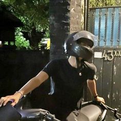 a person on a motorcycle wearing a helmet and holding the handlebars to their bike