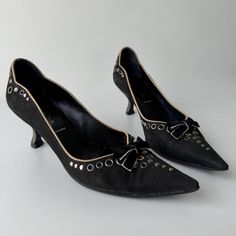 Early 2000's Prada black nubuck suede leather pointed toe kitten heel pumps with sculptural silver heels, tonal velvet bow detail, grommet and stud embellishments throughout. Marked size EU 35 Fits like US 5/5.5 Insole: 22.5 cm Heel: 6 cm Studded Fitted Heels For Formal Occasions, Designer Black Kitten Heels For Evening, Formal Studded Fitted Heels, Formal Fitted Studded Heels, Designer Black Kitten Heels For Formal Occasions, Gothic Clown, Clown Shoes, Vintage Prada, Black Kitten Heels