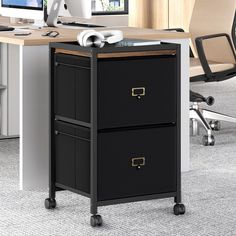 an office desk with two drawers and a computer monitor on the top one is open