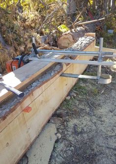 a man is using a chainsaw to cut wood in half on the side of a road