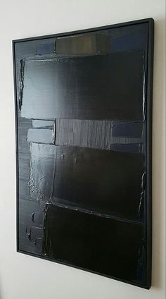 a black piece of art hanging on the wall