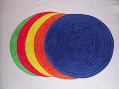 four different colors of jute rugs on top of each other in the shape of a circle