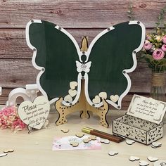 there is a wooden sign with a butterfly on it next to other decorations and flowers