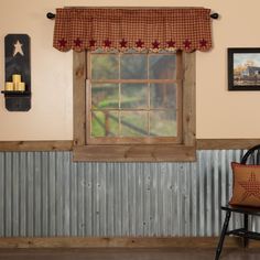 a chair sitting in front of a window next to a wall with pictures on it