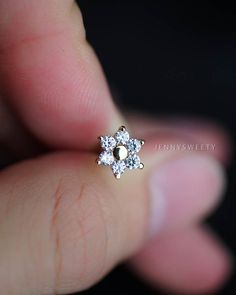 a close up of a person's hand holding a ring with two diamonds on it