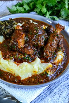 a plate filled with meat and potatoes covered in gravy