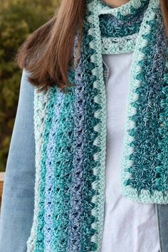 a woman wearing a blue and white crocheted scarf