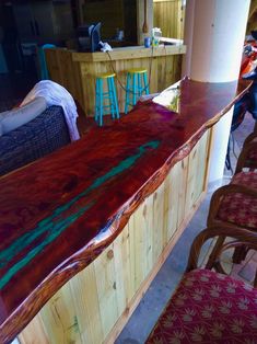 a counter top made out of wood with chairs around it