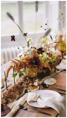 the table is set with flowers, candles and other things to decorate it for dinner