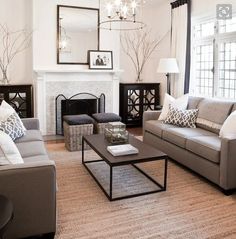 a living room filled with furniture and a fire place in front of a white fireplace