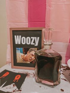 a bottle of booze sitting on top of a table next to a framed photo