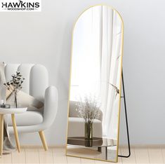 a large mirror sitting next to a white couch