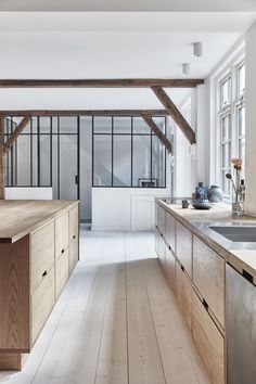 an image of a kitchen with wood floors and white walls, in the middle of a room