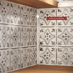 the corner of a kitchen with white and black tiles on it's backsplash