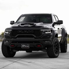 a black ram truck parked on top of a parking lot