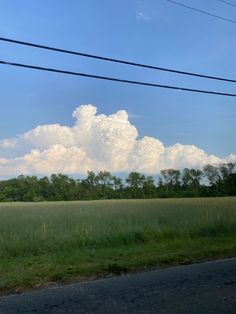 the sky is blue and white with some clouds in it, as well as green grass