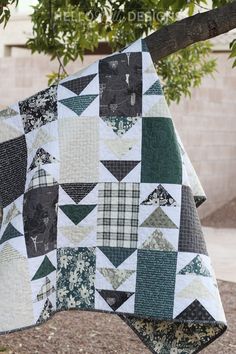 a patchwork quilt hanging from a tree