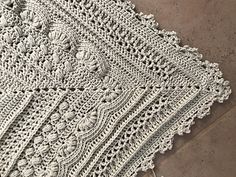 a white crocheted doily is laying on the floor