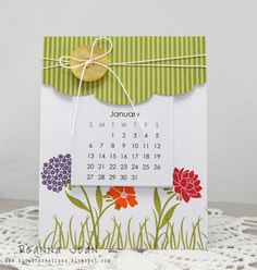 a calendar card on a doily with a tag tied to it's side