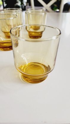 four glasses filled with oil sitting on top of a table