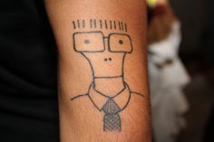 a man's arm with a drawing of a person wearing glasses and a tie