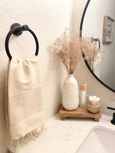 a bathroom with a sink, mirror and towel rack on the counter next to it